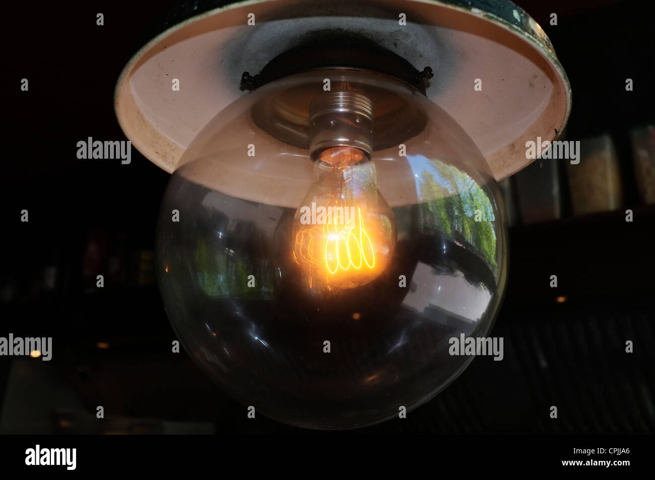 Bassa potenza elettrica grande luce incandescente filamento lampadina in una caffetteria Foto Stock