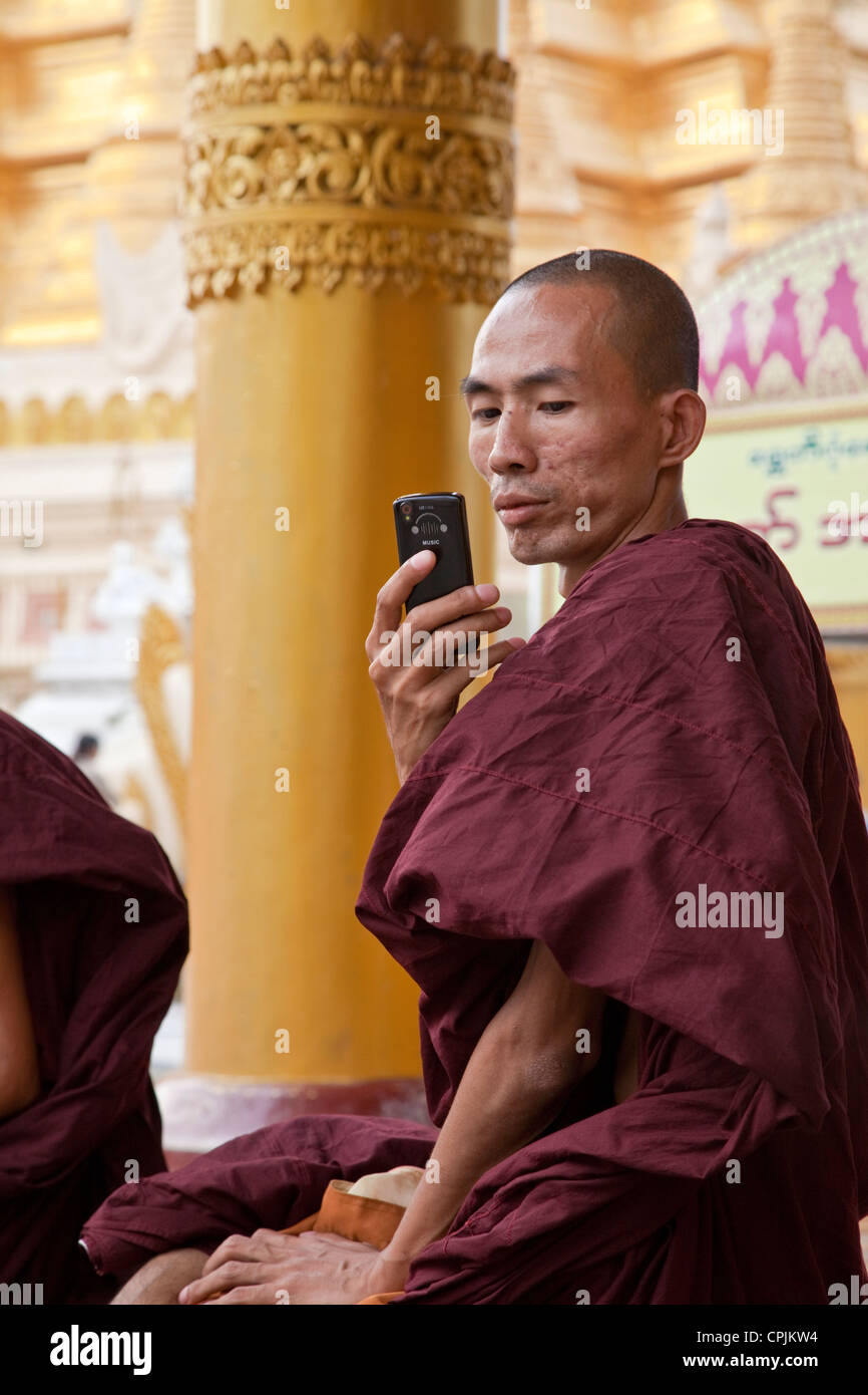Myanmar Birmania. Shwedagon pagoda Yangon, Rangoon. Monaco buddista con un telefono cellulare. Foto Stock