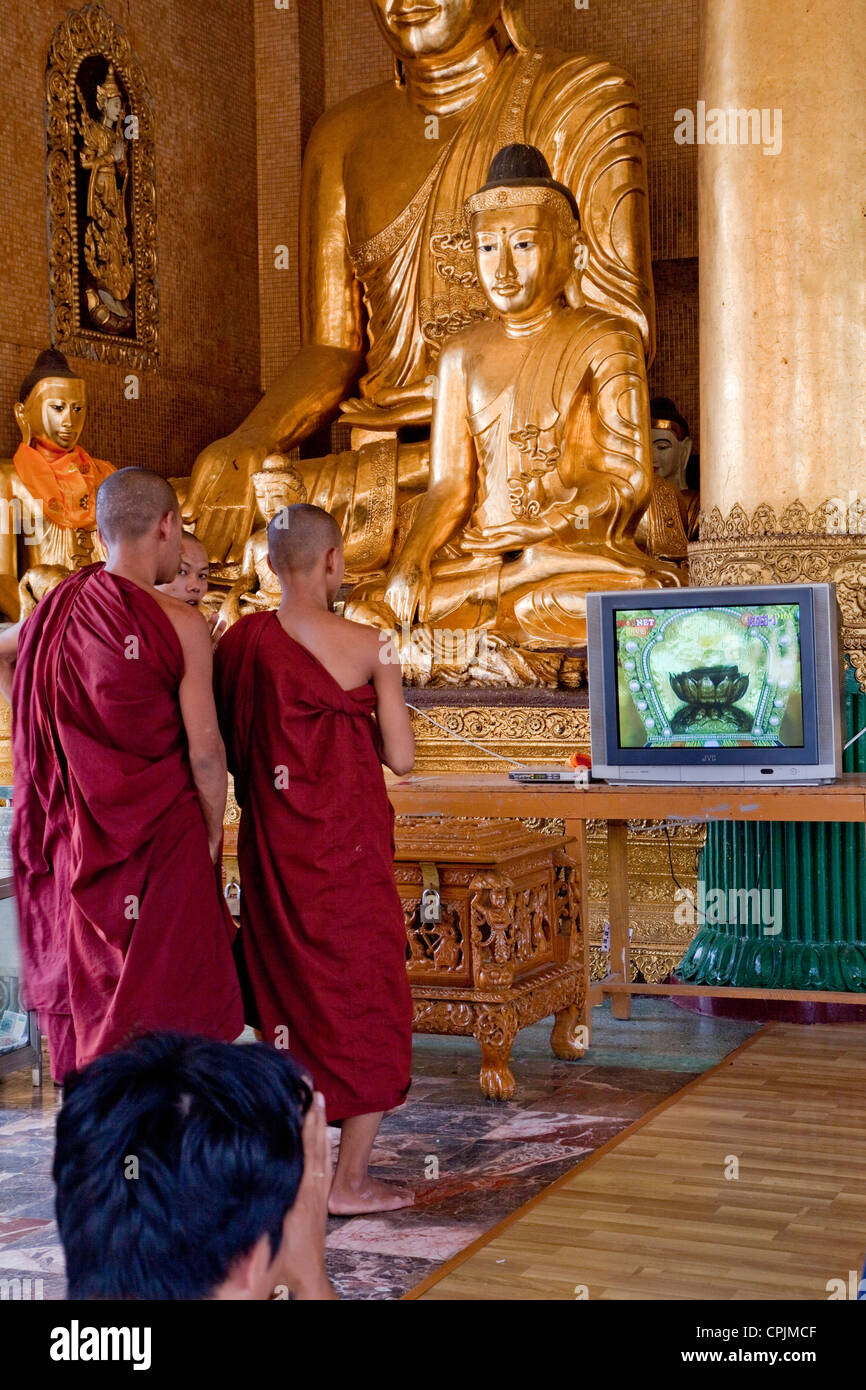 Myanmar Birmania. Shwedagon pagoda Yangon, Rangoon. Giovani monaci presso il Buddha Santuario. Foto Stock