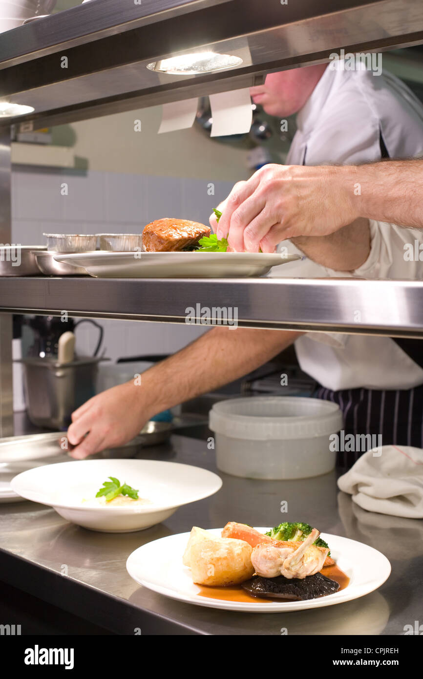 Chefs preparare il cibo al pass Foto Stock