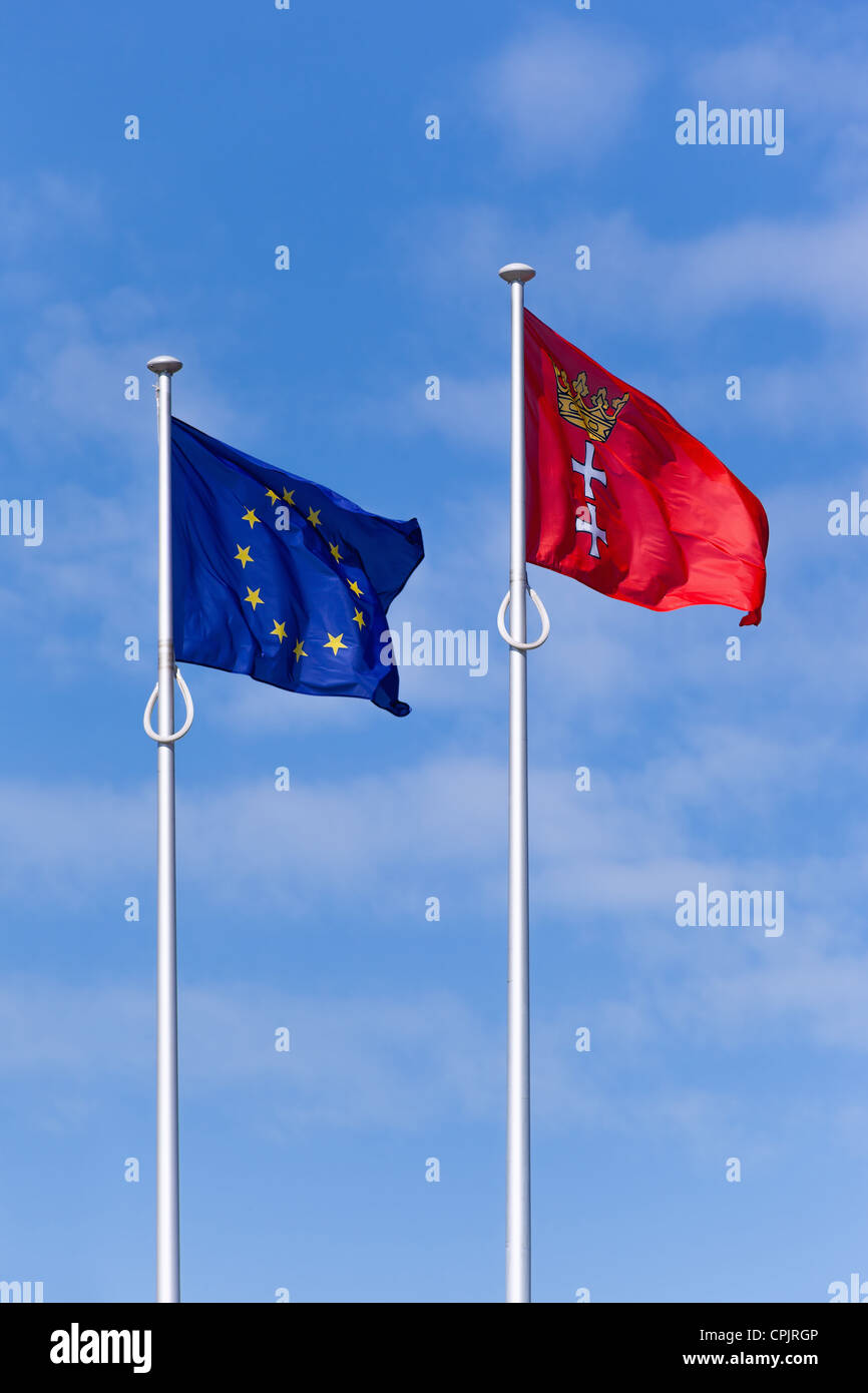 La bandiera di Danzica (Polonia) e l'Unione europea volare sotto il cielo blu. Foto Stock