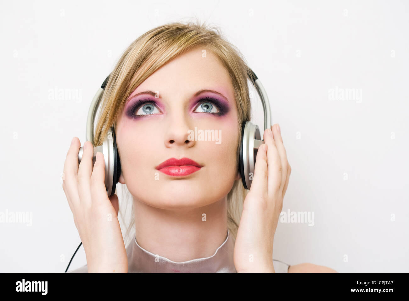 Bella bionda elettro-pop gir godendo la musica nelle cuffie. Foto Stock