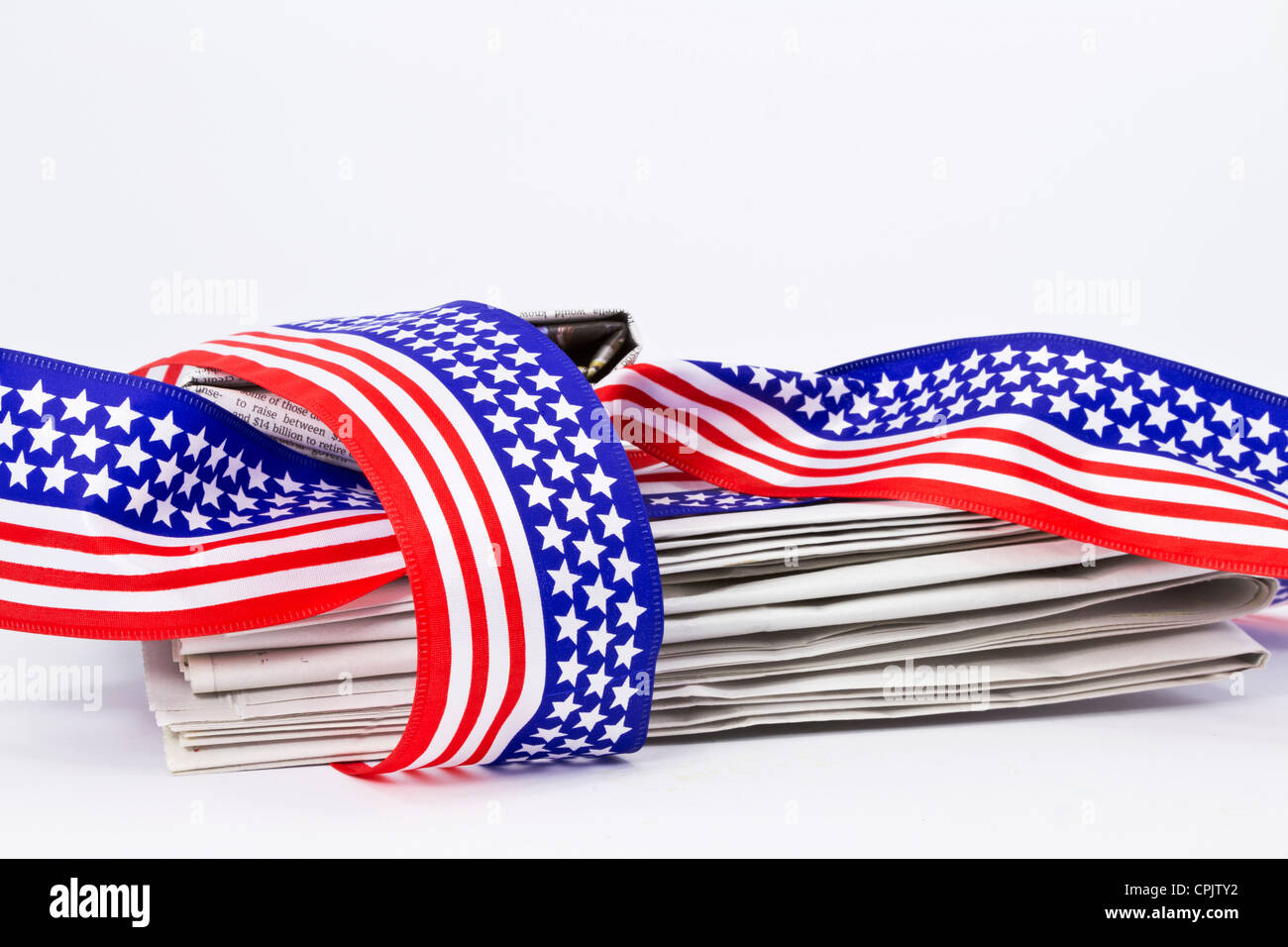 Pila di giornale avvolto in modo lasco nella bandiera degli Stati Uniti colori e simboli a stelle e strisce. Foto Stock