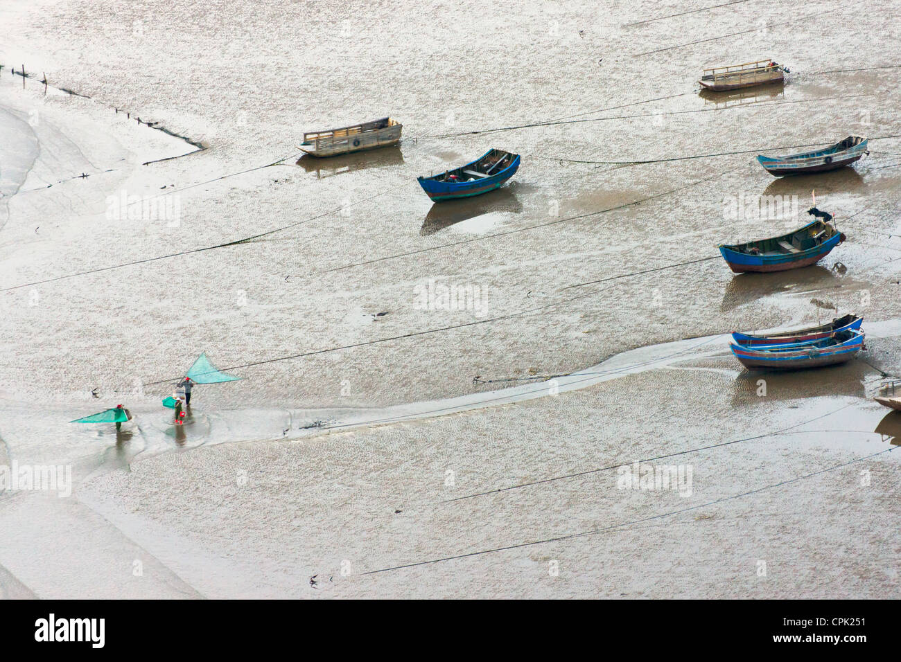 I pescatori che trasportano il pesce net e barche di pescatori sulla spiaggia di fangoso, il Mar della Cina orientale, Xiapu, Fujian, Cina Foto Stock