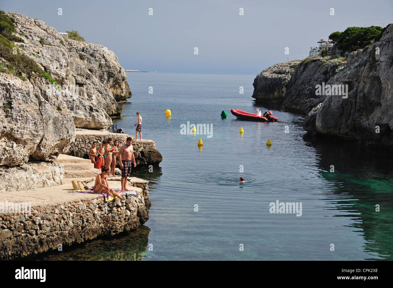 Bagnanti sulle sporgenze rocciose, Cala en Forcat, Menorca, isole Baleari, Spagna Foto Stock