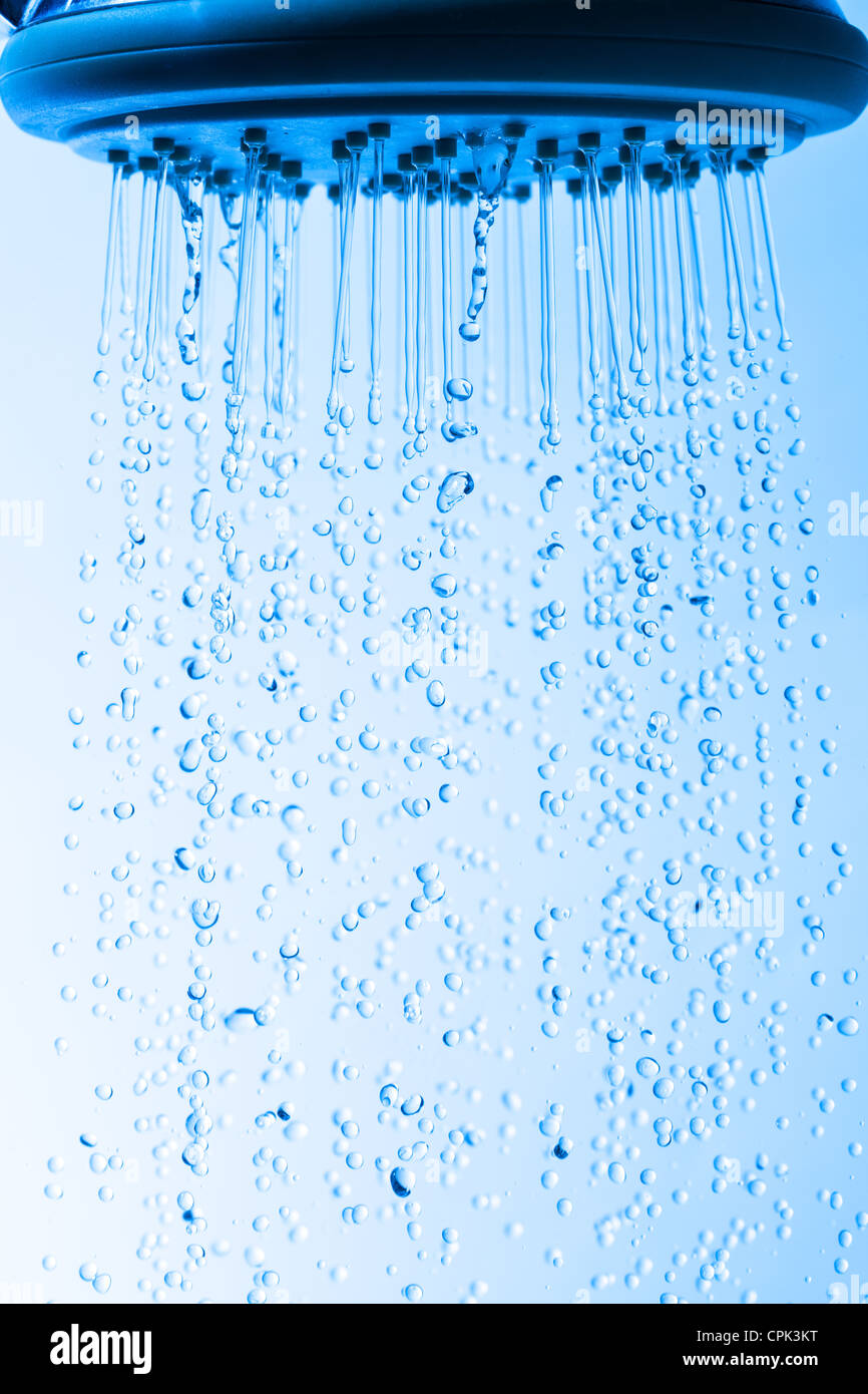 Testa di doccia con acqua di goccioline, sfondo blu Foto Stock