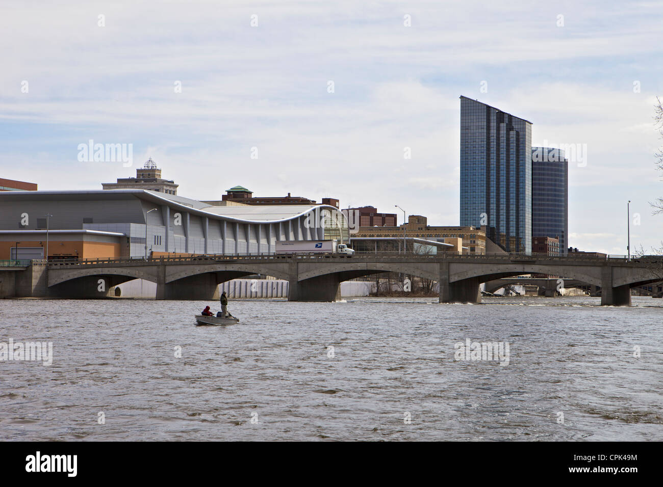 Due persone di pesca in barca sul grande fiume con il centro di Grand Rapids in background Foto Stock