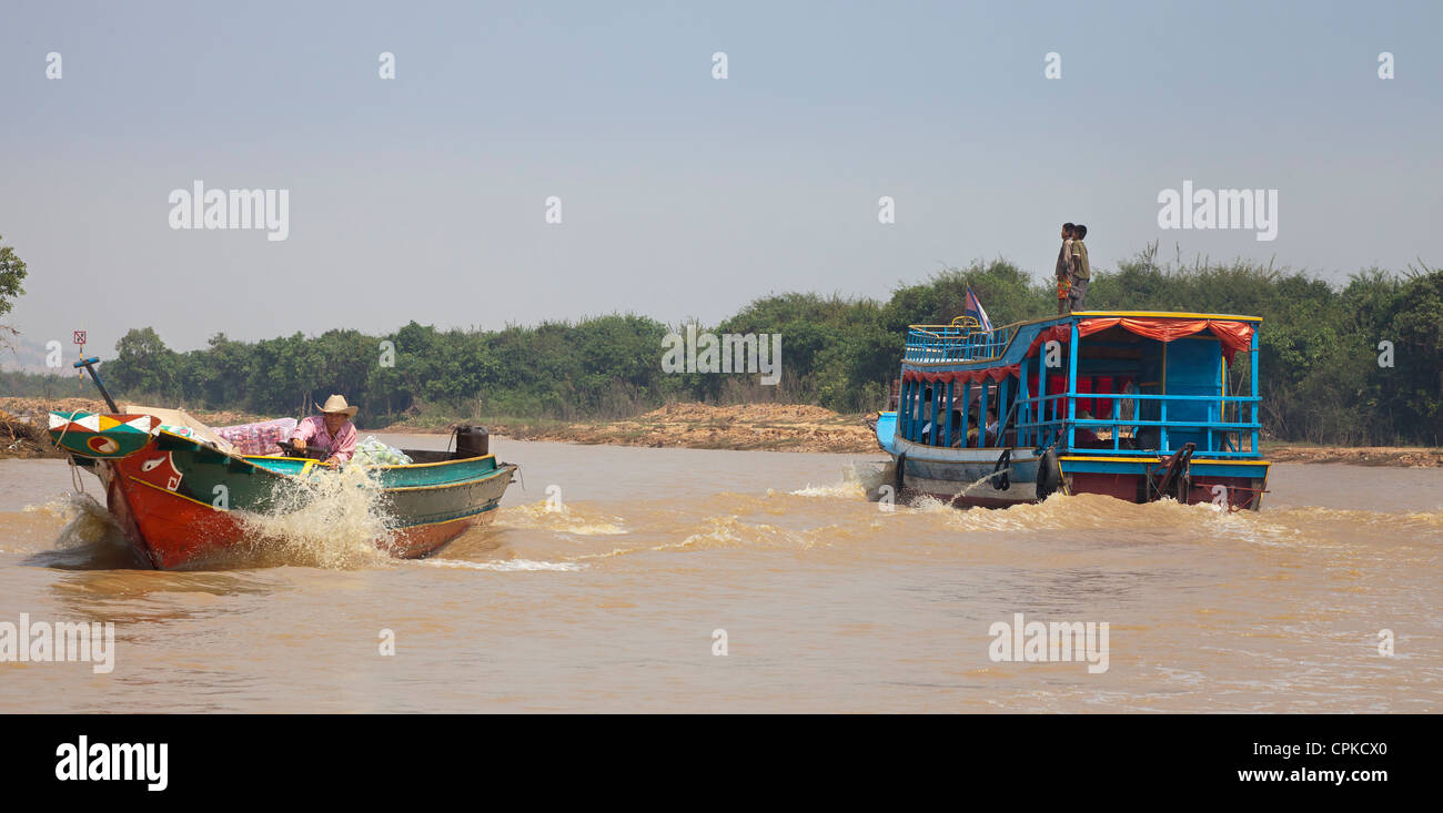 Lago Tonle Sap, Siem Reap, Cambogia. Barca veloce e traghetto con bambini a cavallo sul tetto. Foto Stock