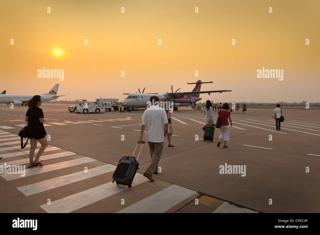 Passeggeri a piedi a bordo di una Cambogia aereo, tramonto Foto Stock