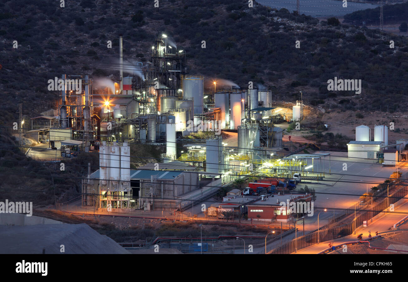 Raffineria di petrolio strutture illuminata di notte Foto Stock
