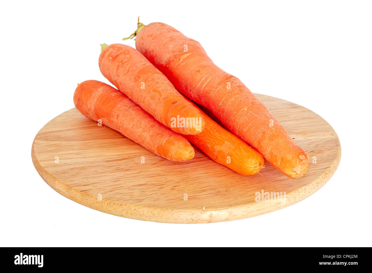 Mazzo di carote fresche sulla tavola di legno isolato su bianco Foto Stock
