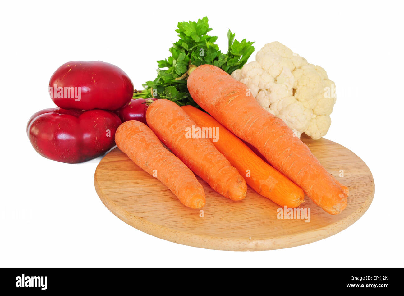 Ortaggi freschi sulla tavola di legno - carote, cavolfiori, peperoni e prezzemolo isolato su bianco Foto Stock