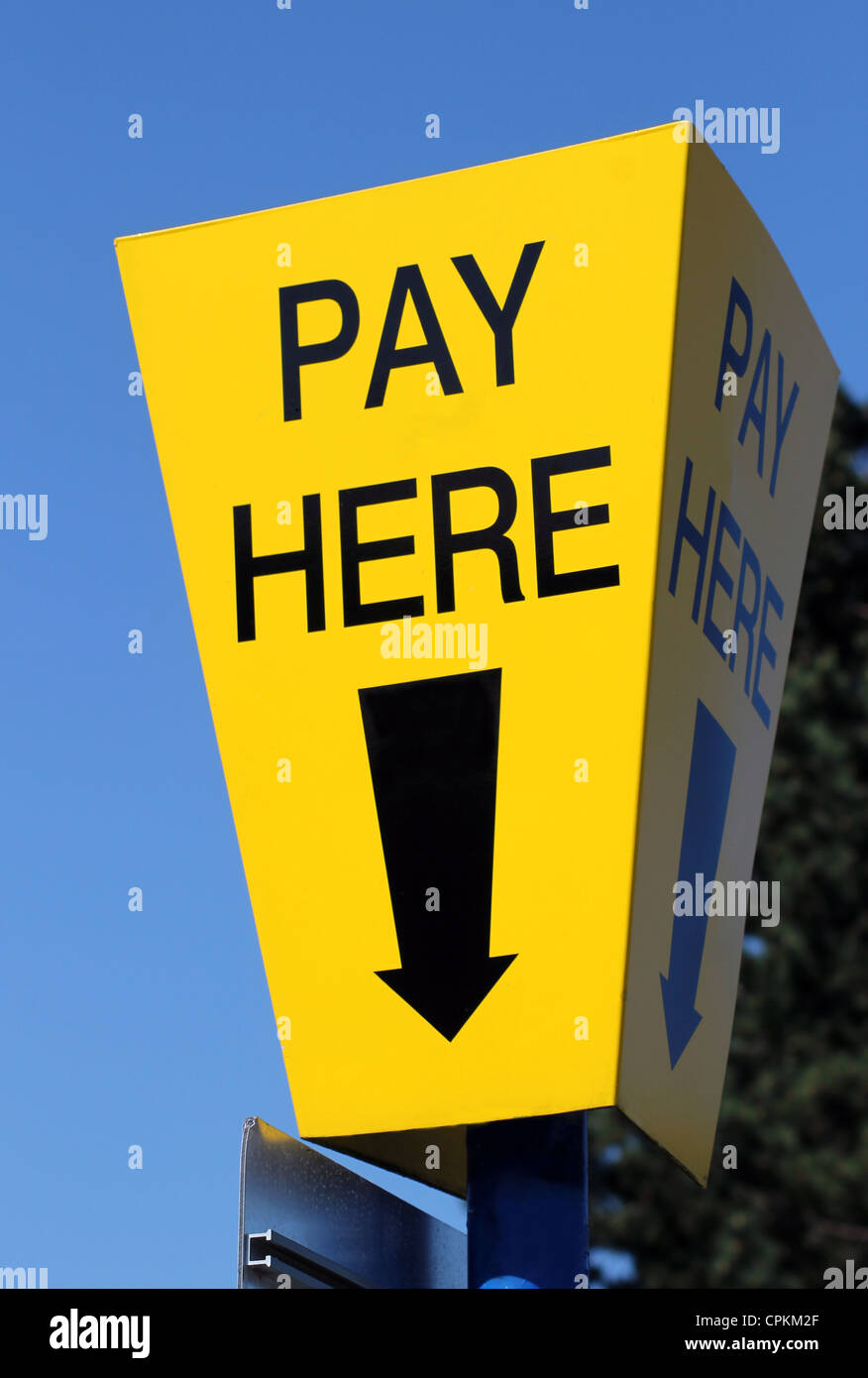 Giallo auto parcheggio paga qui segno con cielo blu di sfondo e la freccia direzionale. Foto Stock