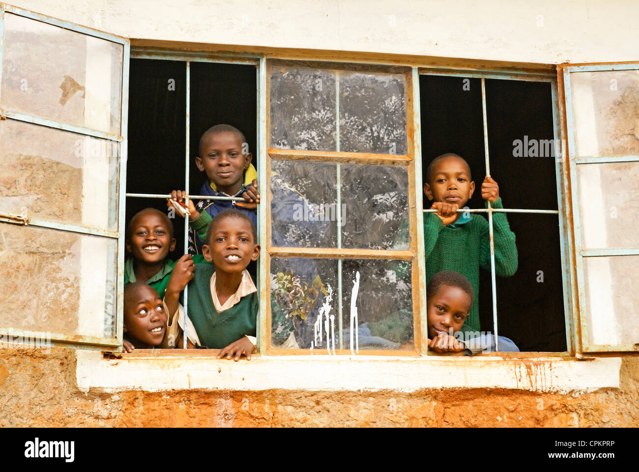 I bambini guardando fuori della finestra della scuola in Kenya Foto Stock