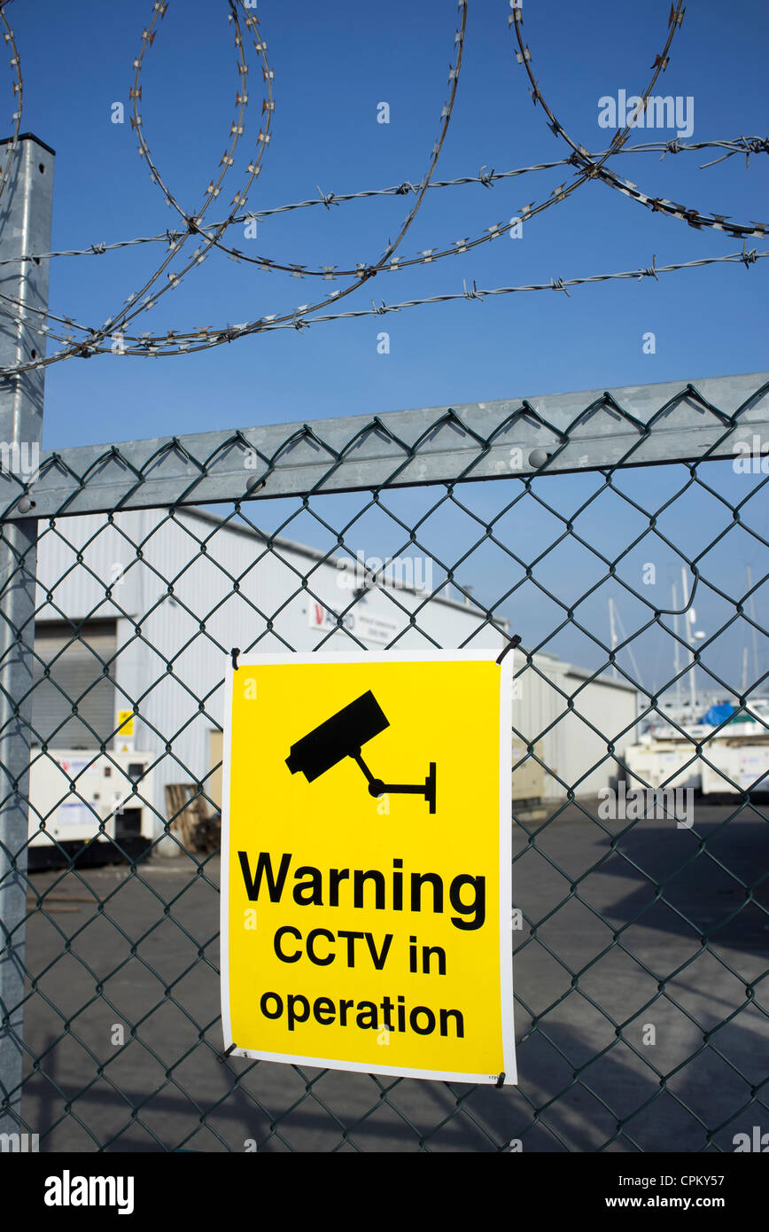 Avvertenza CCTV in operazione segno su una recinzione Foto Stock