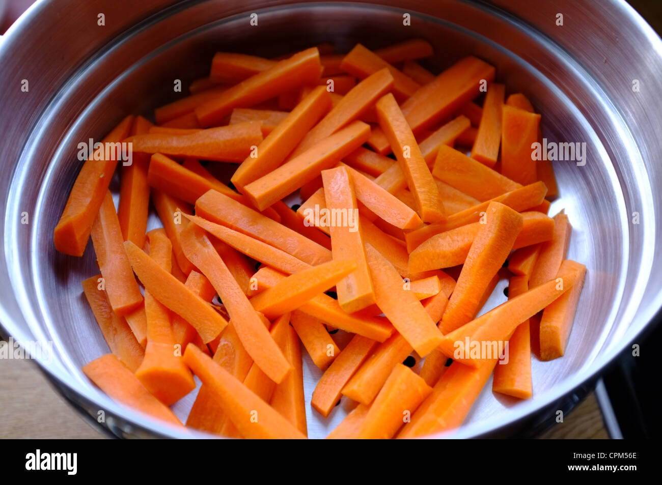 Le carote fresche lavate e batoned in uno scolapasta Foto Stock
