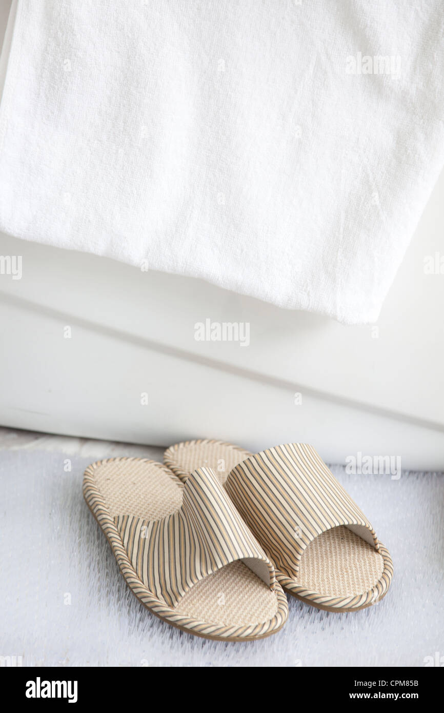 Pantofole sul tappetino da bagno dalla vasca da bagno con portasciugamani Foto Stock