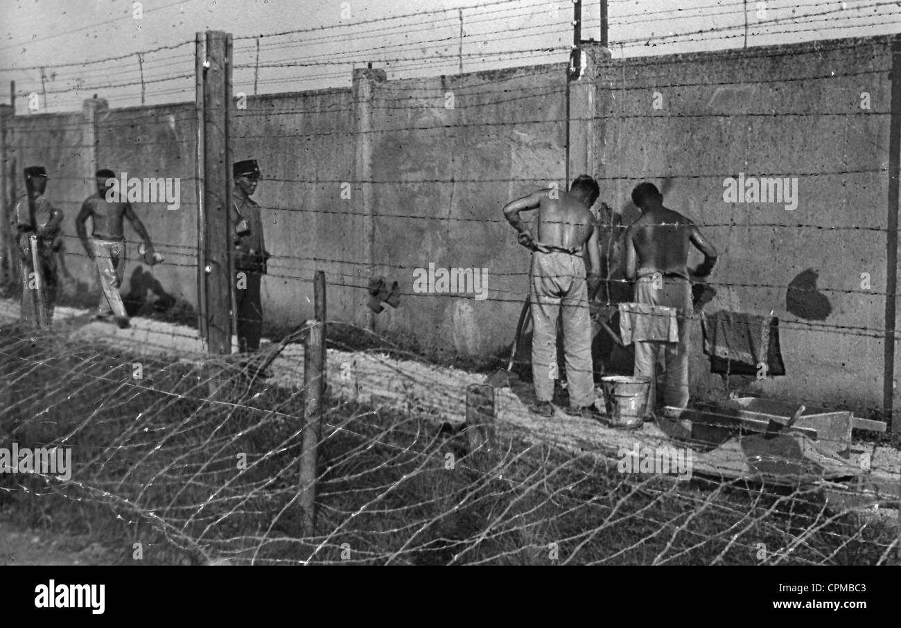 Gli internati Camp costruzione di muri del campo di concentramento di Dachau sotto la sorveglianza di una guardia SS, 1933 (foto b/n) Foto Stock