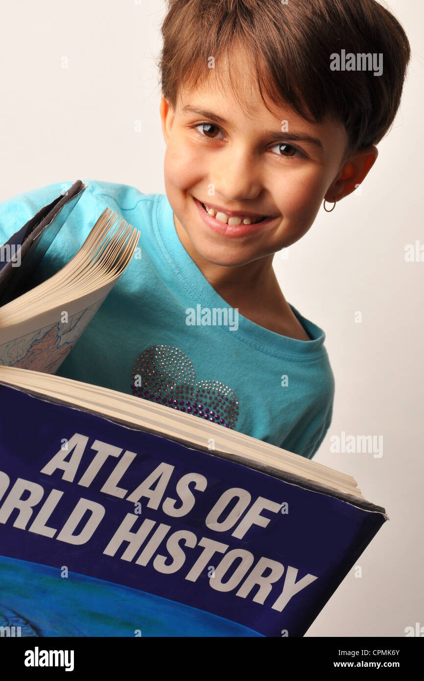 Adolescente bi-razziale sorridente femmina durante la lettura di Atlante del mondo libro di storia Foto Stock