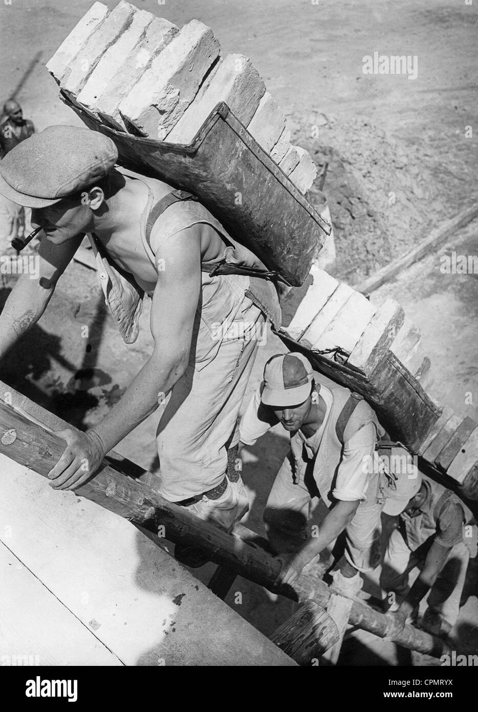 Lavoratori portano mattoni, 1939 Foto Stock