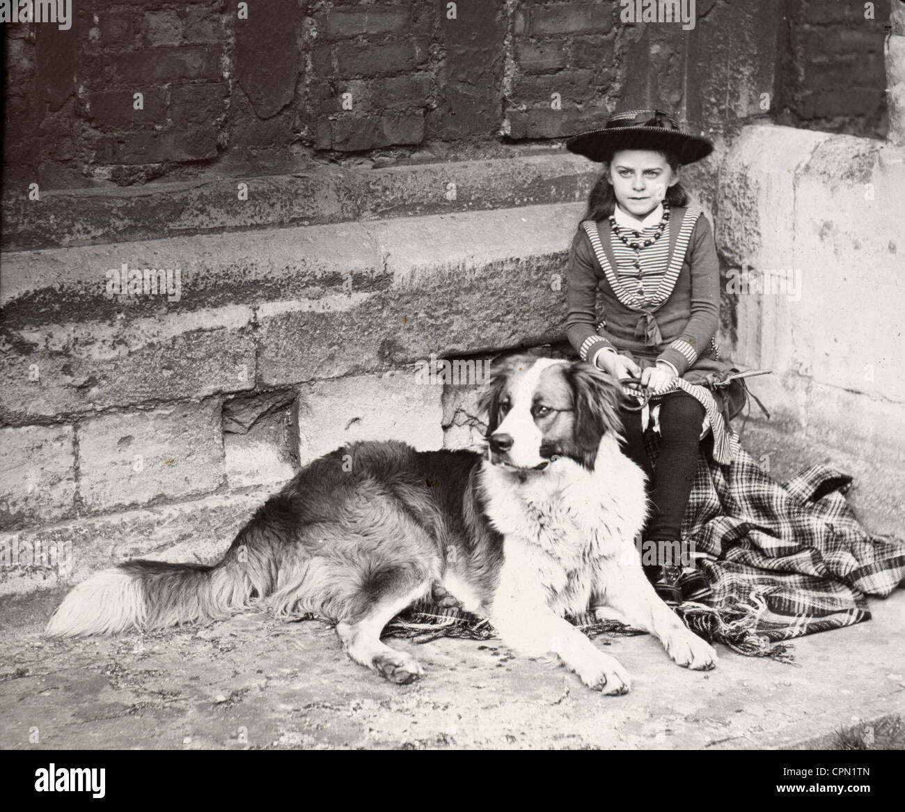 Poco era Edoardiana ragazza attende in angolo con Collie Foto Stock