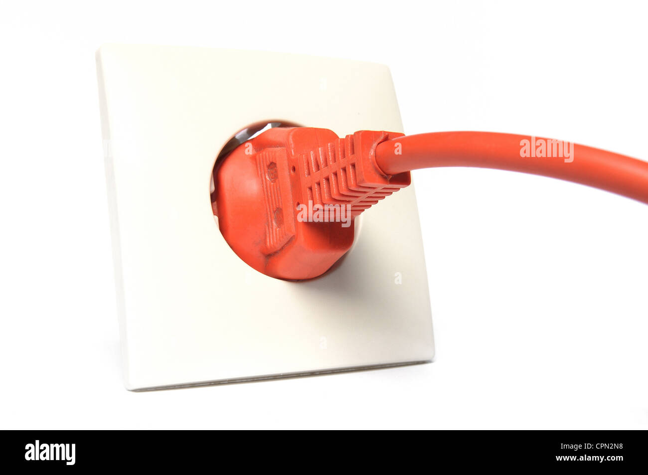 Colore arancio spina di alimentazione in una presa su sfondo bianco Foto Stock