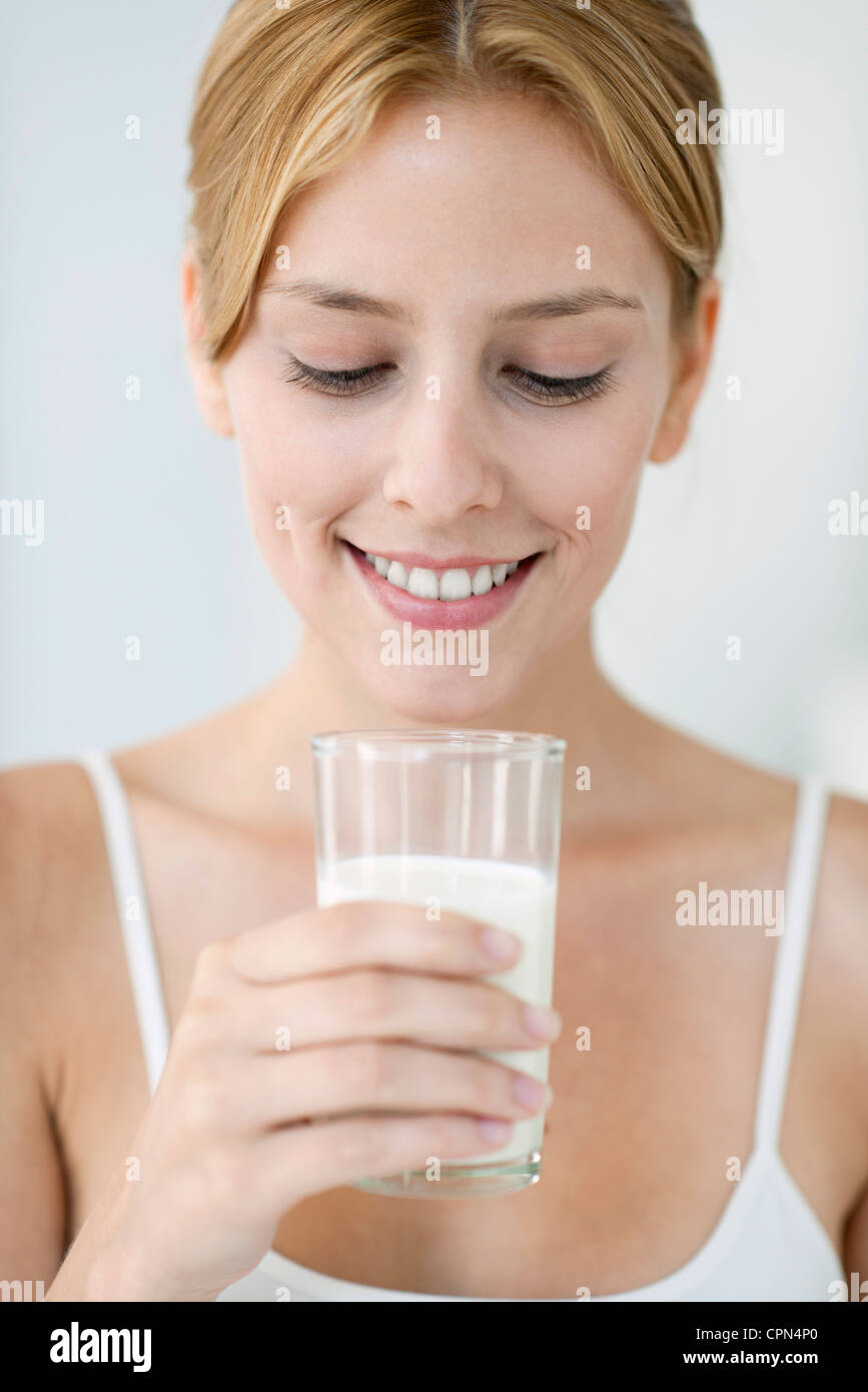 Giovane donna tenendo un bicchiere di latte Foto Stock