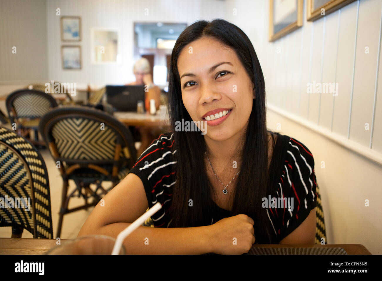 Donna filippina seduta all'interno Cafe de France ristorante. Città Lapu-Lapu, Metro Cebu Mactan Island, Visayas nelle Filippine. Foto Stock