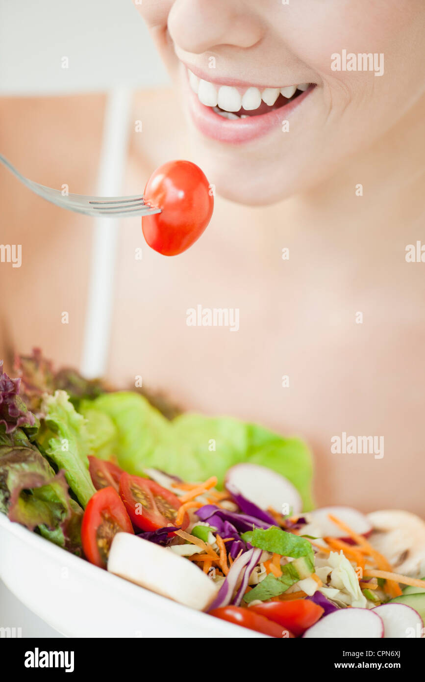 Donna di mangiare insalata, ritagliato Foto Stock