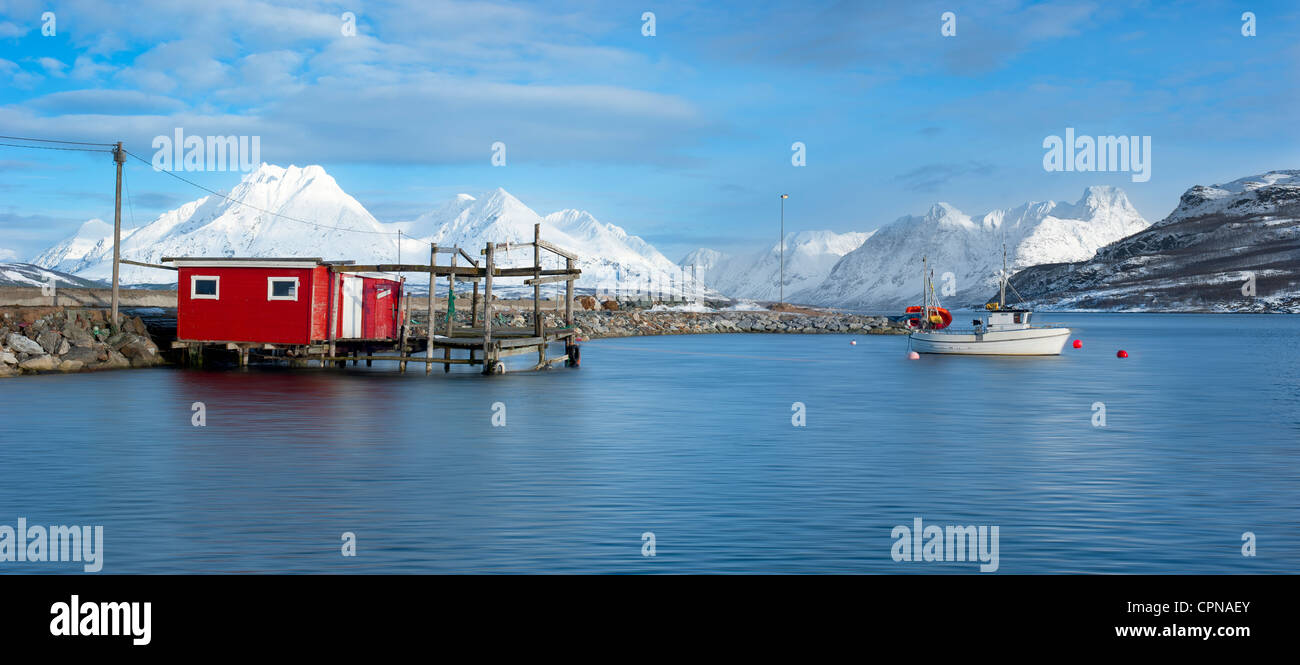 Barche e un capannone con le Alpi Lyngs in background Foto Stock