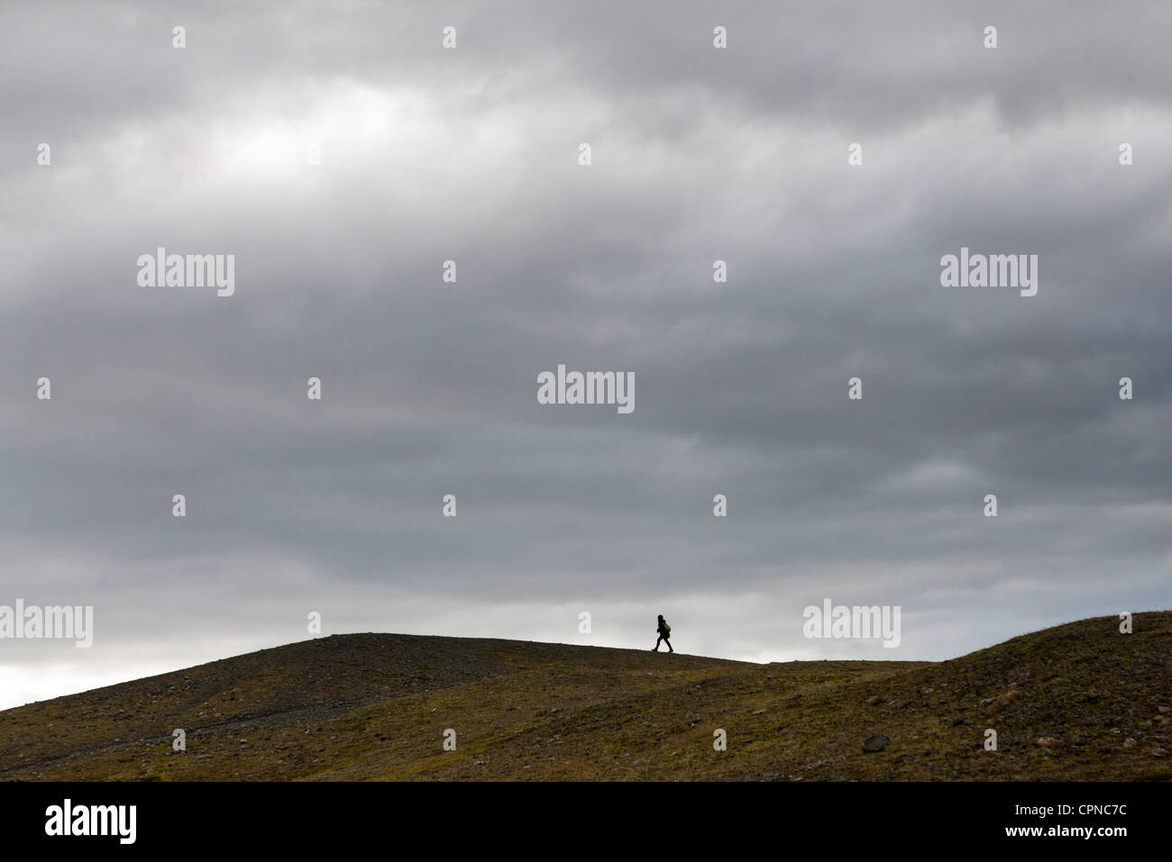 L'Islanda, la persona che cammina lungo la collina sterile Foto Stock