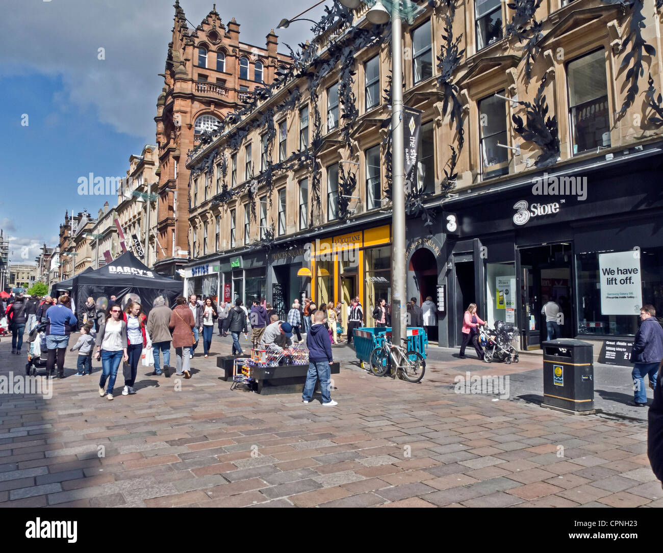 Gli acquirenti e i visitatori a Buchanan Street presso il Princes Square building a Glasgow Scozia su una soleggiata giornata di primavera Foto Stock