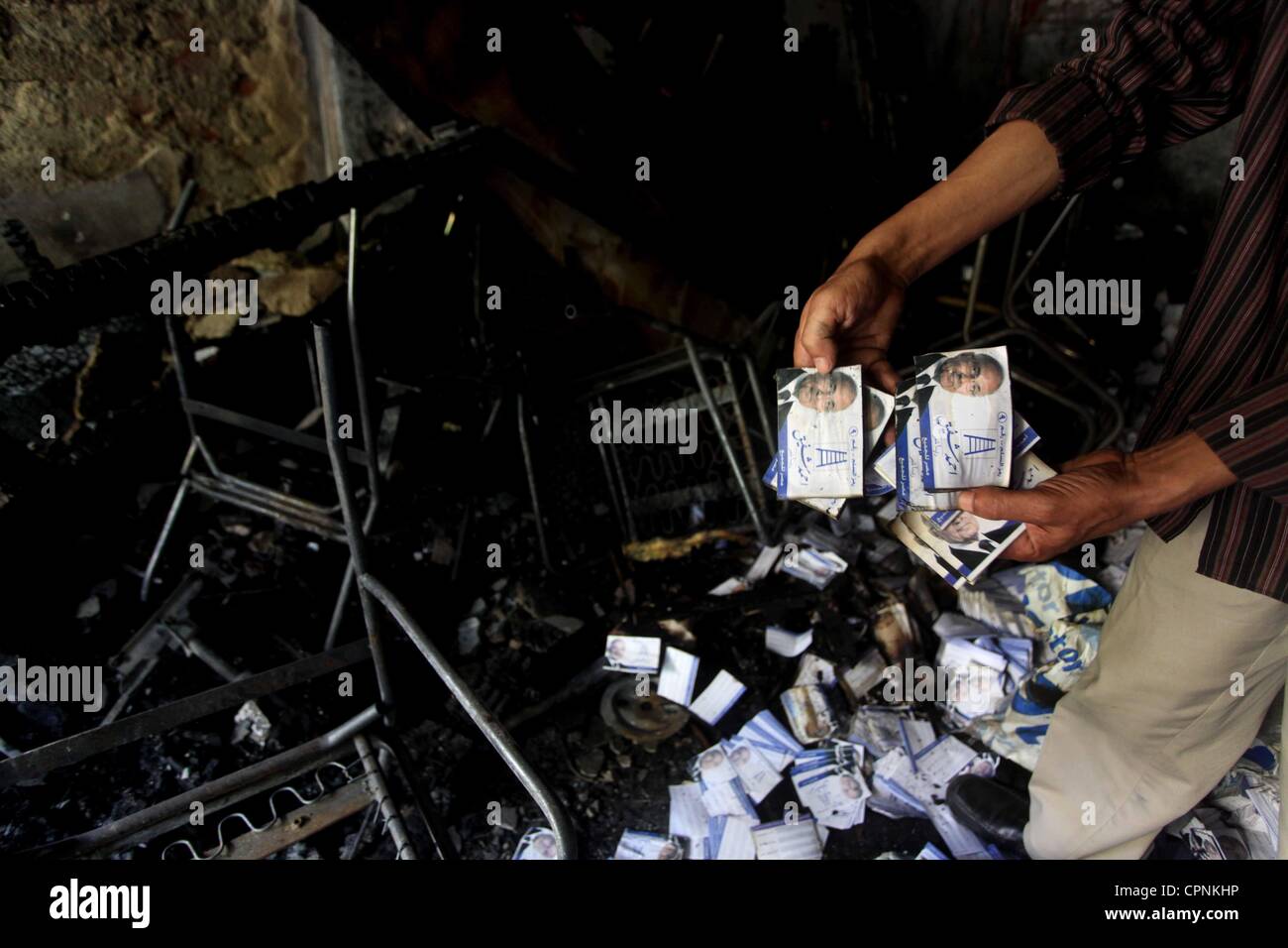 28 maggio 2012 - Il Cairo, il Cairo, Egitto - un uomo mostra i volantini del candidato presidenziale Ahmed Shafiq presso la scena di bruciato la sede della campagna di Shafiq al Cairo il 29 maggio 2012. Un gruppo di dimostranti egiziani incendiare la sede il lunedì, lo stato news agenzia riferito, dopo l'ex-primo mi Foto Stock