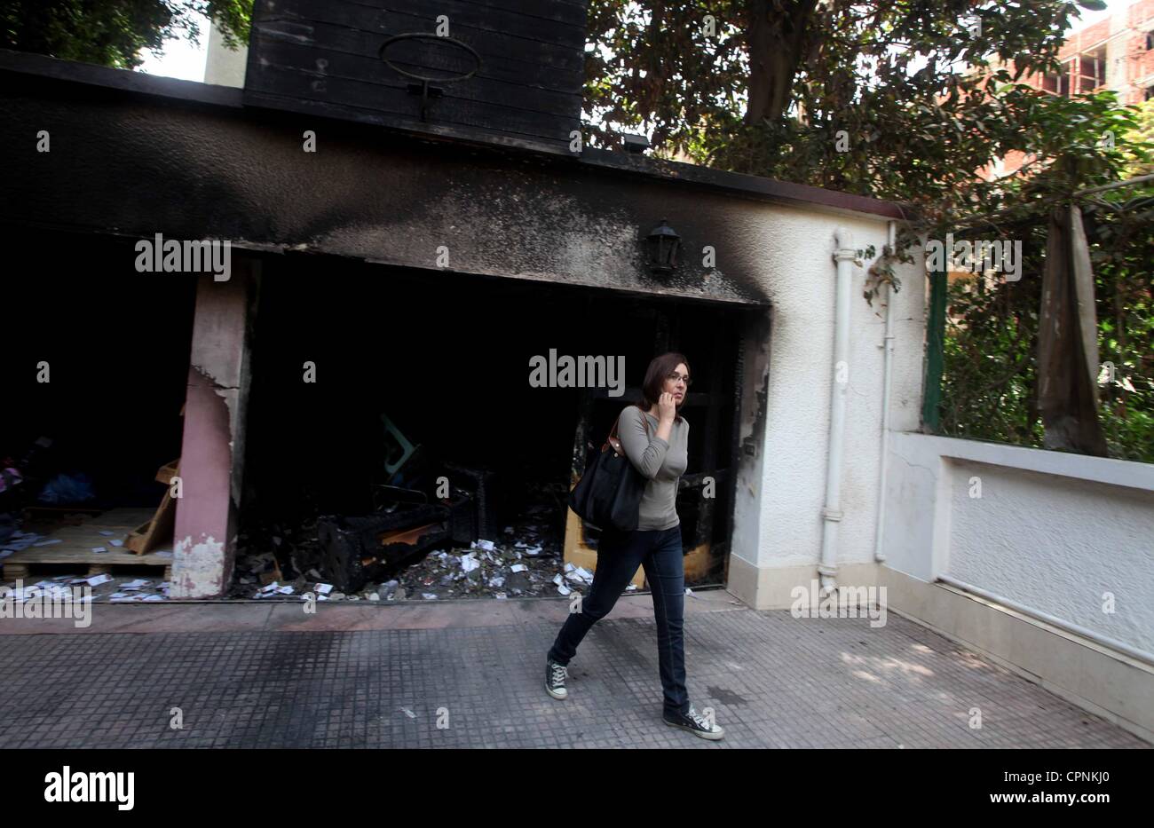 28 maggio 2012 - Il Cairo, il Cairo, Egitto - donna egiziana passeggiate nella parte anteriore di bruciato la sede della campagna del candidato ed ex primo ministro Ahmed Shafiq al Cairo il 29 maggio 2012. Un gruppo di dimostranti egiziani incendiare la sede il lunedì, lo stato news agenzia riferito, dopo l'ex-primo Foto Stock