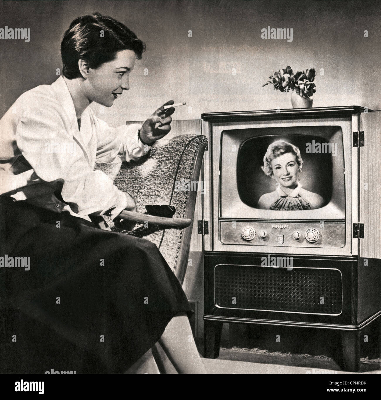 Koss, Irene, 3.8.1928 - 2.5.1996, presentatore televisivo tedesco, primo annunciatore televisivo tedesco dopo la guerra, 1950 - 1962 a NWDR, più tardi NDR, a metà lunghezza, come spettatore di fronte ad un televisore, uno dei suoi colleghi annunciatore televisivo Angelika Feldmann è sullo schermo, Germania, 1955, Foto Stock