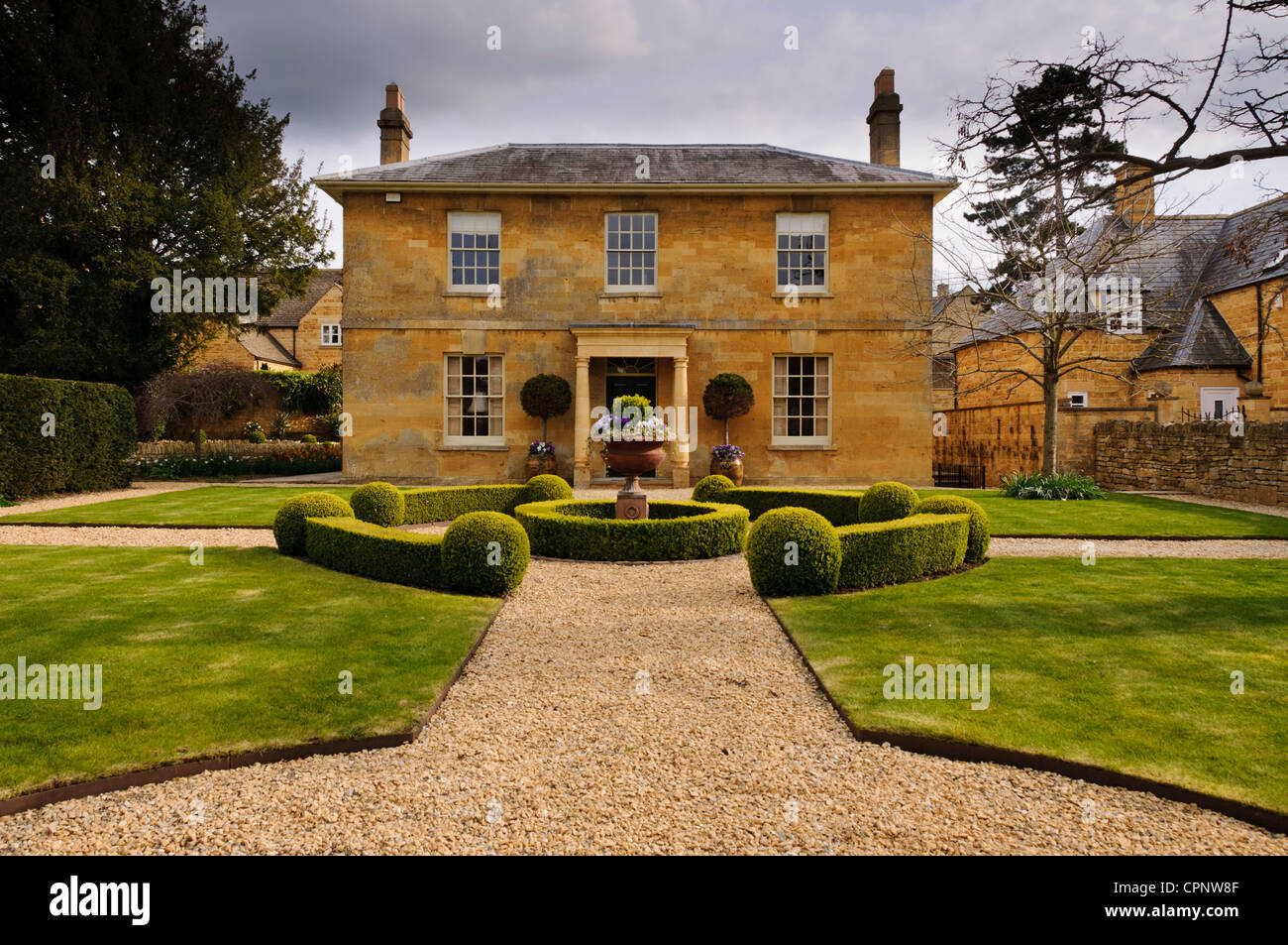 Perfettamente simmetriche color miele Cotswold stone house e il suo giardino anteriore, Broadway, Worcestershire, Cotswolds, REGNO UNITO Foto Stock