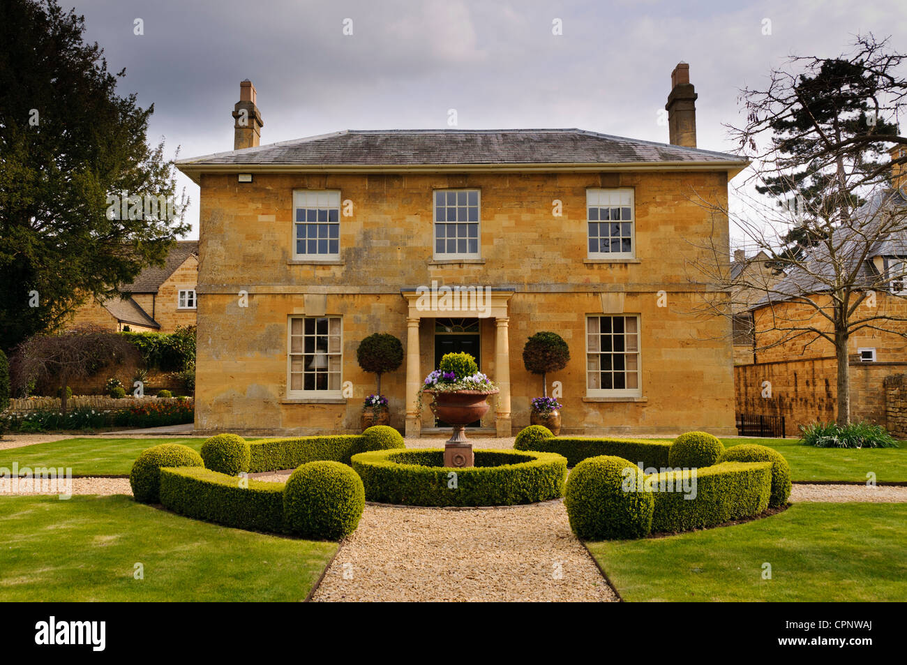 Perfettamente simmetriche color miele Cotswold stone house e il suo giardino anteriore, Broadway, Worcestershire, Cotswolds, REGNO UNITO Foto Stock