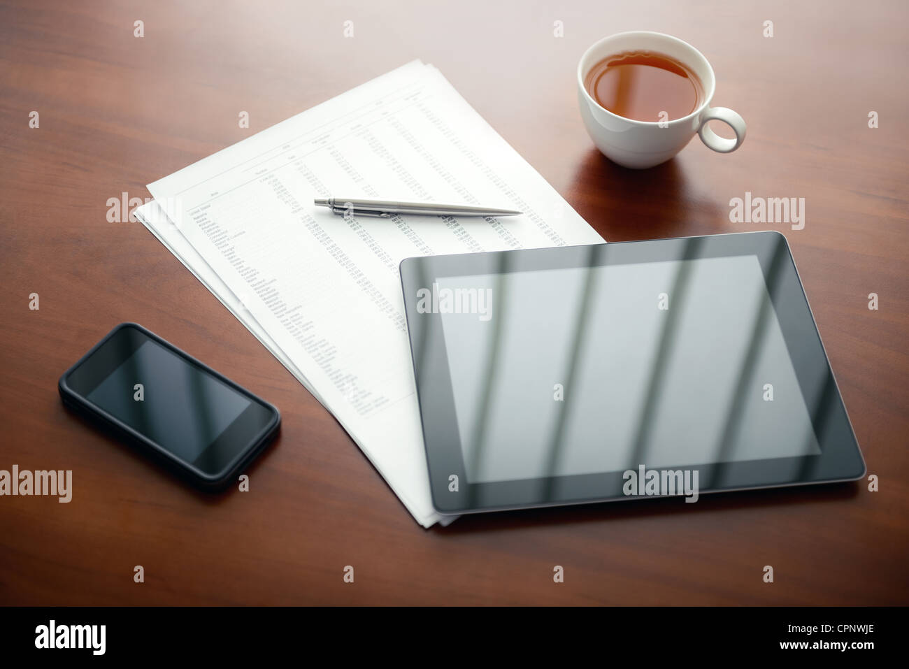 Ambiente di lavoro moderno con tavoletta digitale e il telefono cellulare, penne e le carte con i numeri. Foto Stock