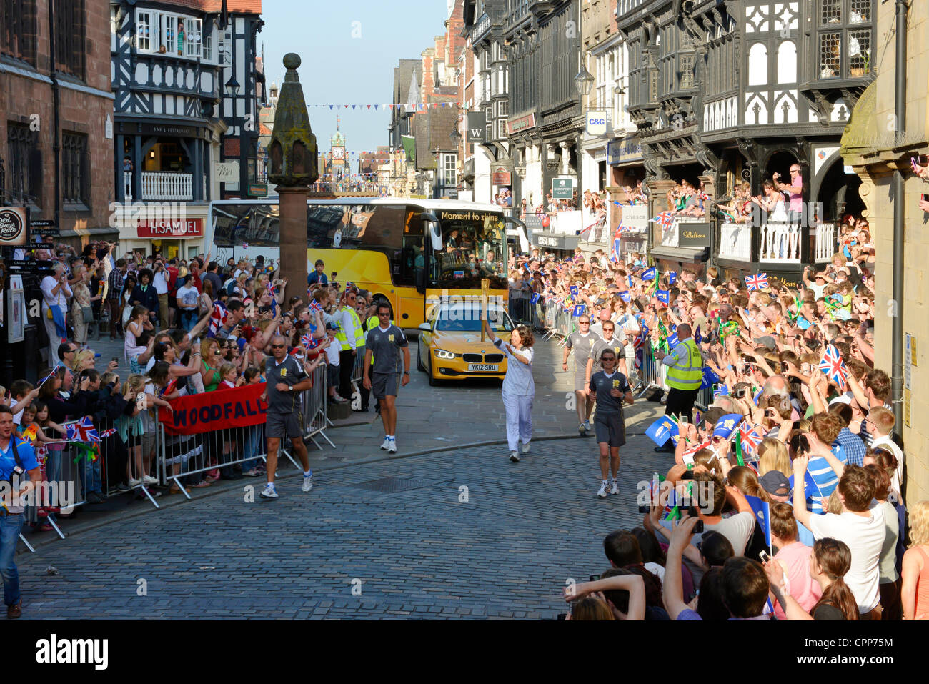 Chester, Regno Unito. 29 Maggio, 2012. La folla lungo le strade di Chester come La Torcia Olimpica rende il modo attraverso il centro città passando la croce e le righe e lungo il Watergate Street verso l'Ippodromo Foto Stock