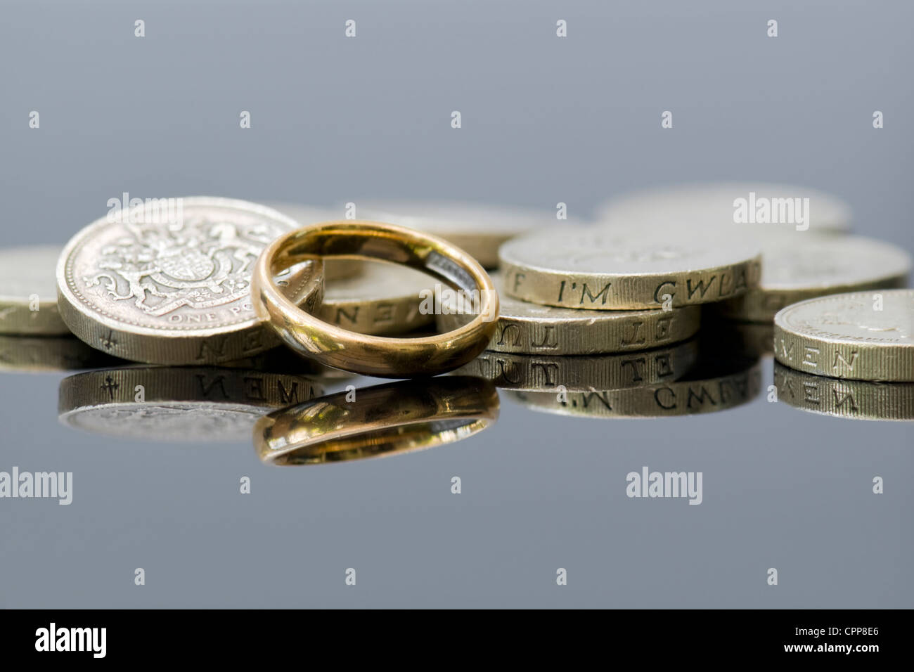 Denaro con anello di nozze che illustra i concetti di pre-contratto nuziale, lo sgretolamento, divorzio consensuale, le pensioni o la pianificazione per il futuro. Foto Stock