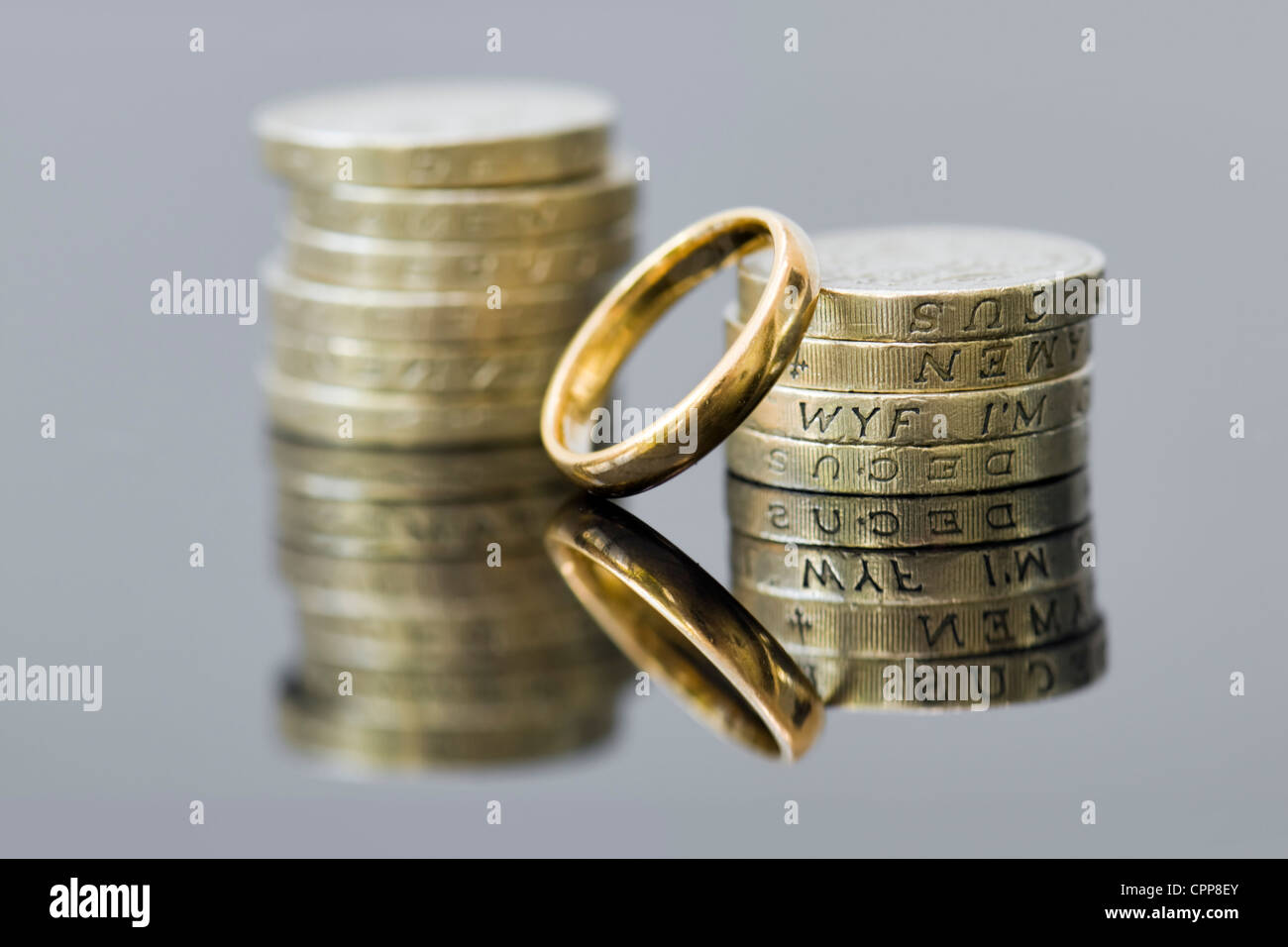 Denaro con anello di nozze che illustra i concetti di pre-contratto nuziale, lo sgretolamento, divorzio consensuale, le pensioni o la pianificazione per il futuro. Foto Stock