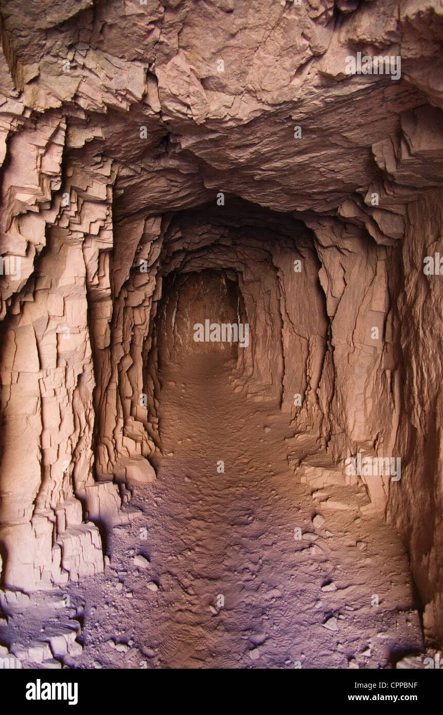 Un buio spooky tunnel nella roccia solida Foto Stock