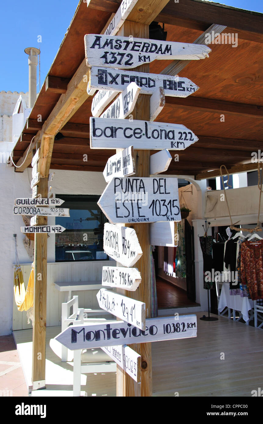 Distanza di destinazione segni al di fuori di un piccolo boutique, Fornells Menorca, isole Baleari, Spagna Foto Stock