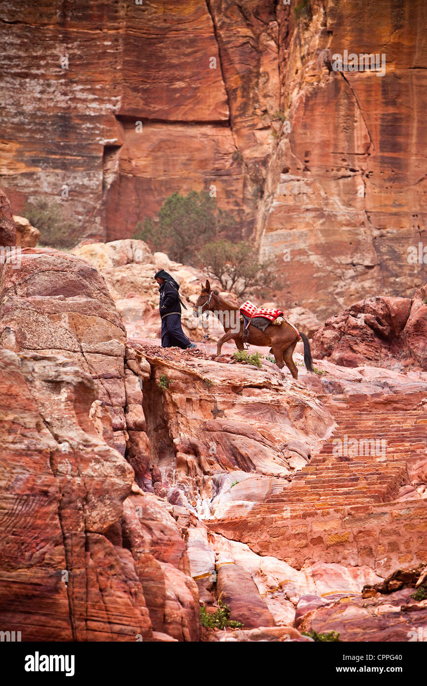 Bedouin salendo dalla strada delle facciate per l'alto luogo del sacrificio (Al-Madbah), Petra, Giordania, Asia Occidentale Foto Stock