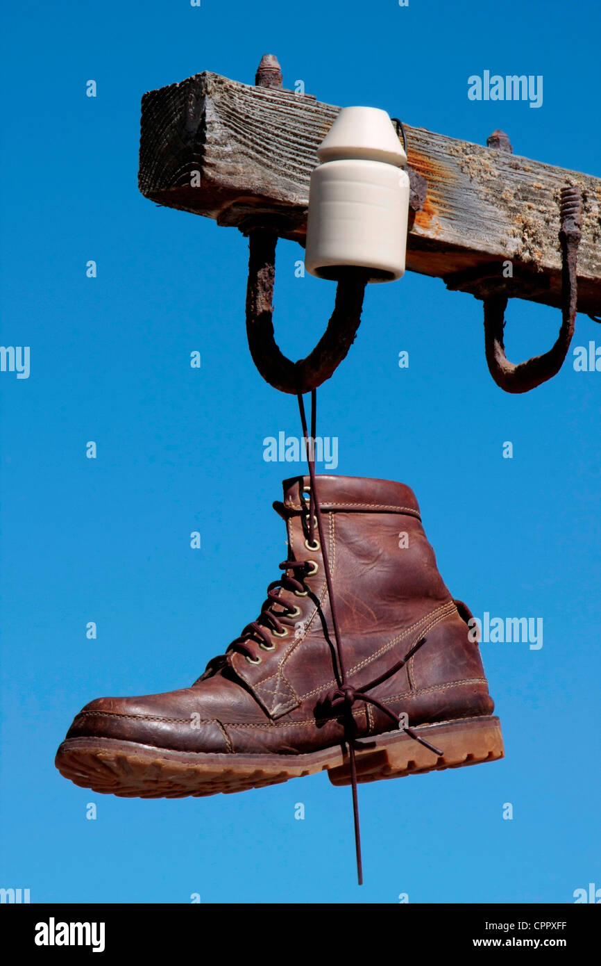 Un boot appesi da un vecchio telefono o palo elettrico. Foto Stock