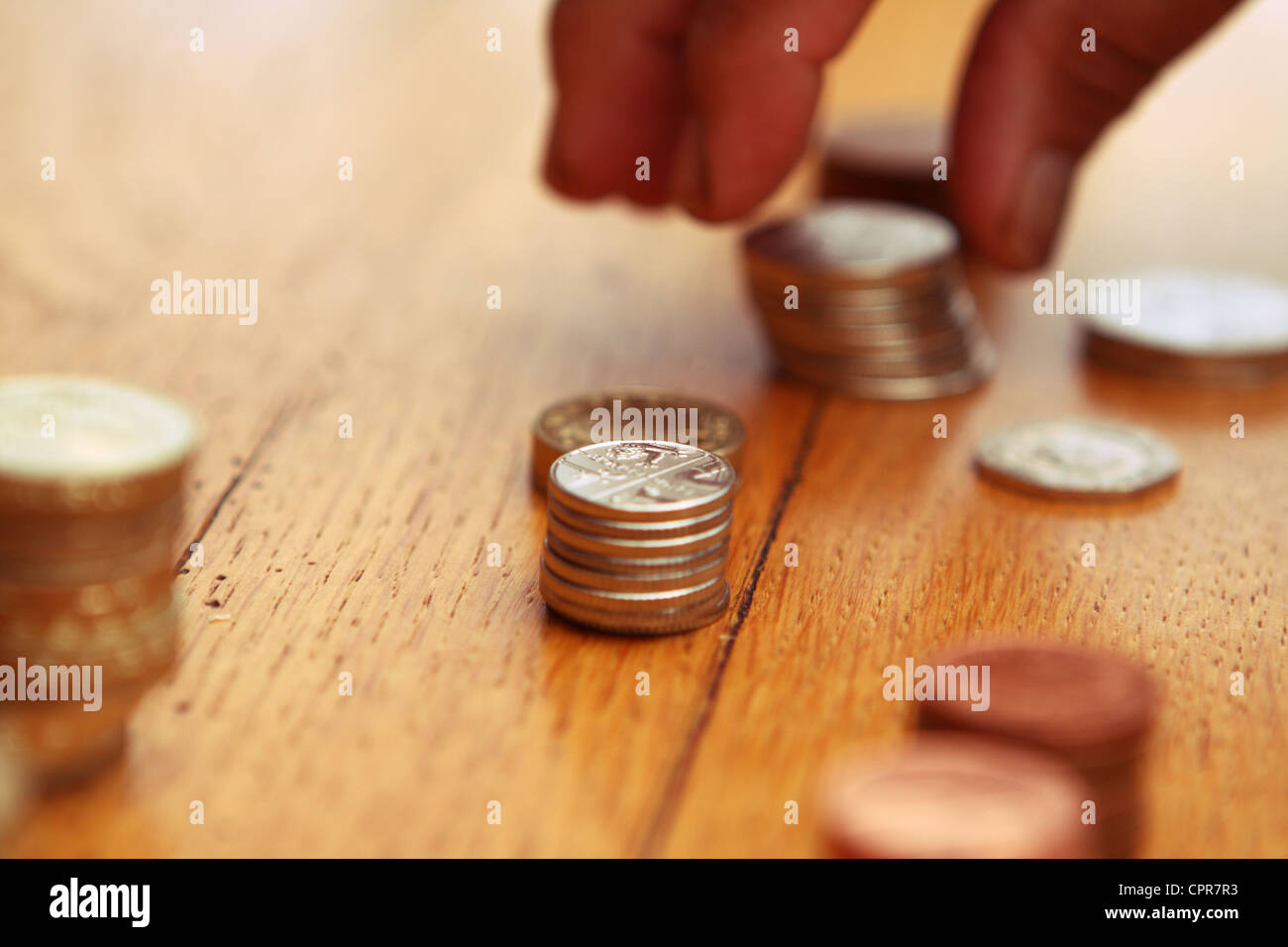 Sterlina monete che vengono ordinati in denominazioni Foto Stock