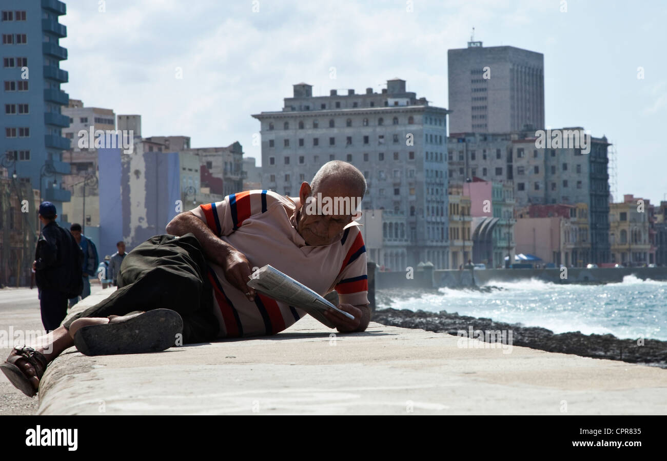 L'uomo la lettura di una carta sul Malecon in Havana Cuba Foto Stock