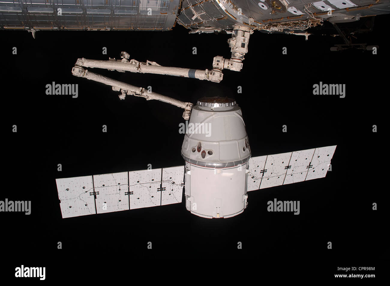 La SpaceX Dragon commerciale cargo craft è agganciato mediante il braccio robotico alla Stazione Spaziale Internazionale il 25 maggio 2012. Dragon è diventato il primo commercialmente sviluppato un veicolo spaziale ad essere lanciato verso la ISS. Foto Stock