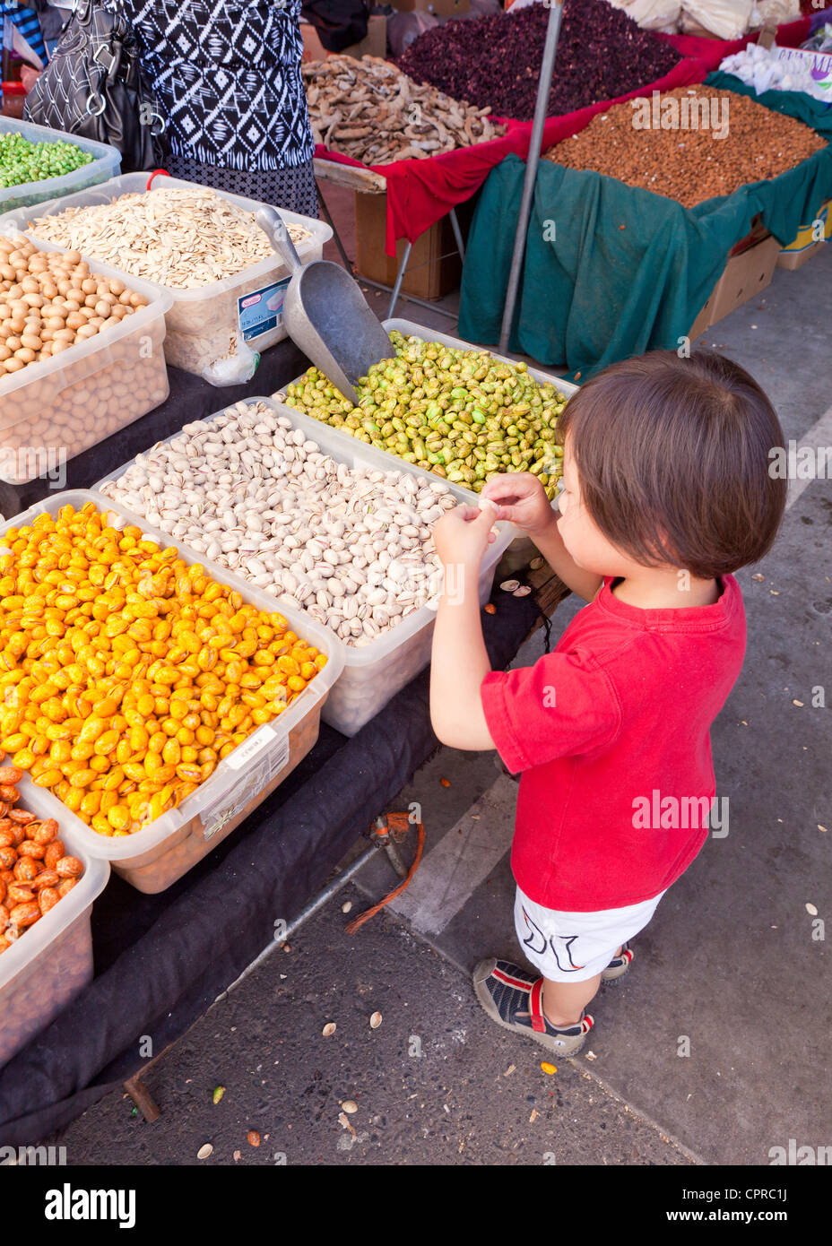 Ragazzo giovane ispezione di frutta secca al mercato degli agricoltori - Stockton California USA Foto Stock