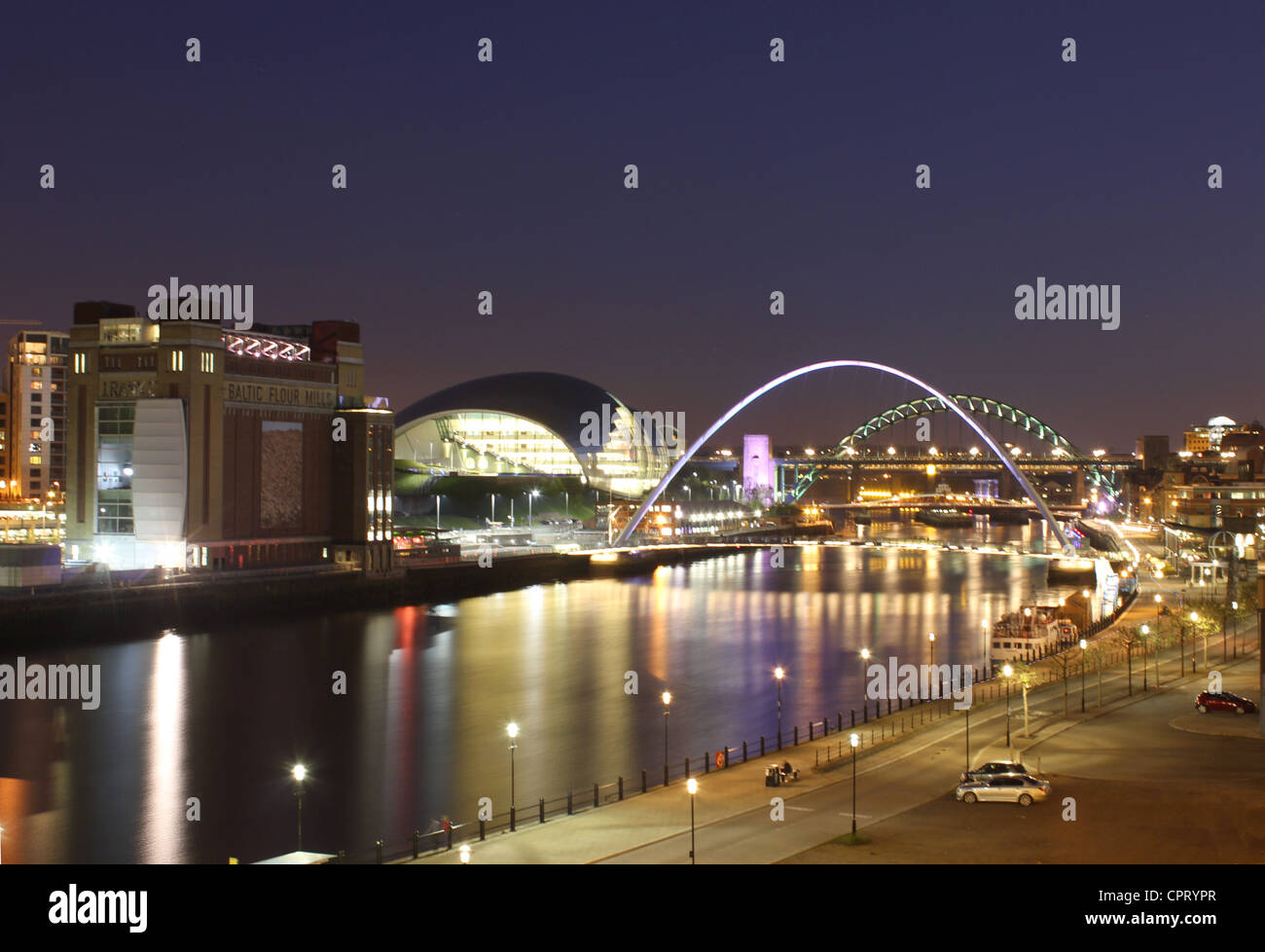 Il Quayside + Fiume Tyne di notte + Newcastle Gateshead ponti illuminati e i monumenti + riflessioni Foto Stock